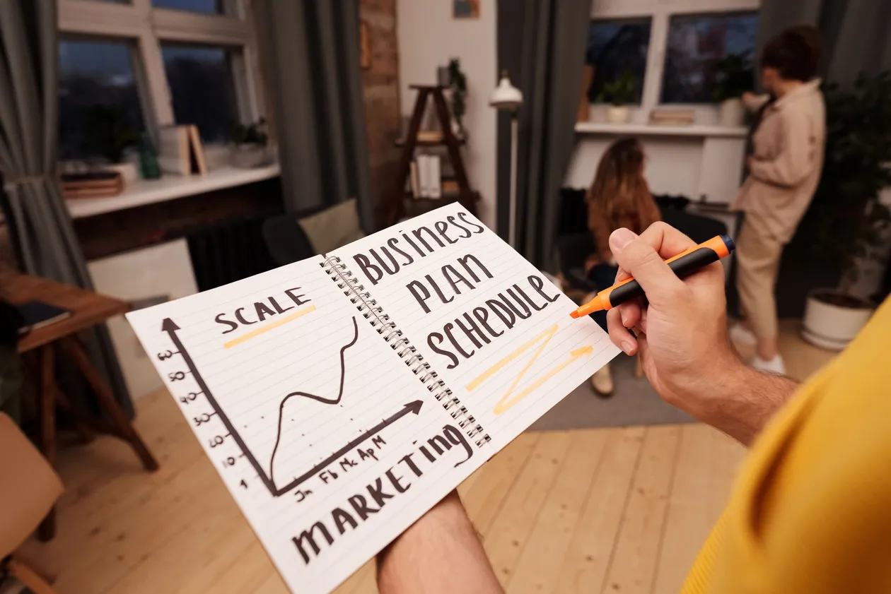 Person holding a notebook with planning details and graph for business strategy