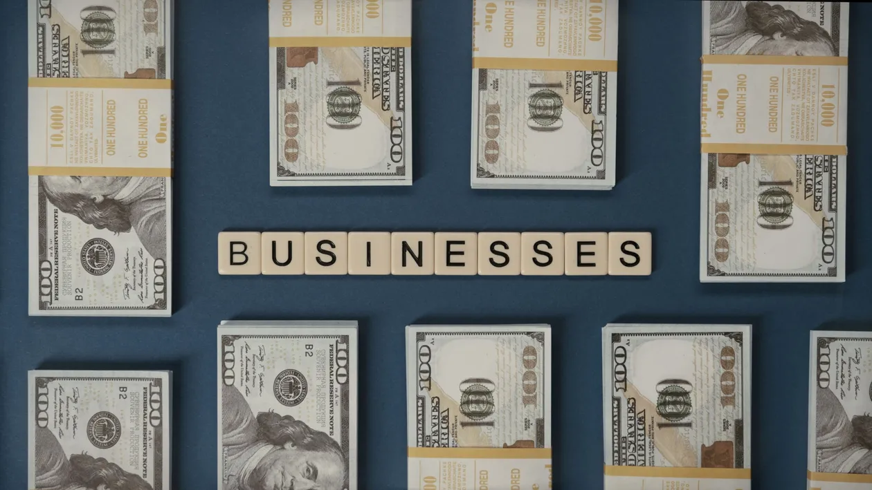 Hundred-dollar bills laid out beside letter tiles