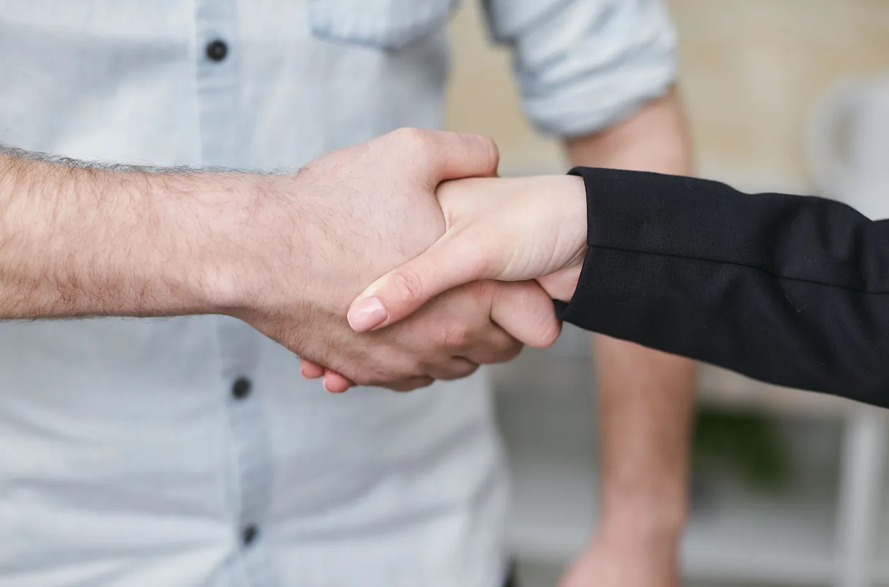 Close-up of two people shaking hands to seal an agreement