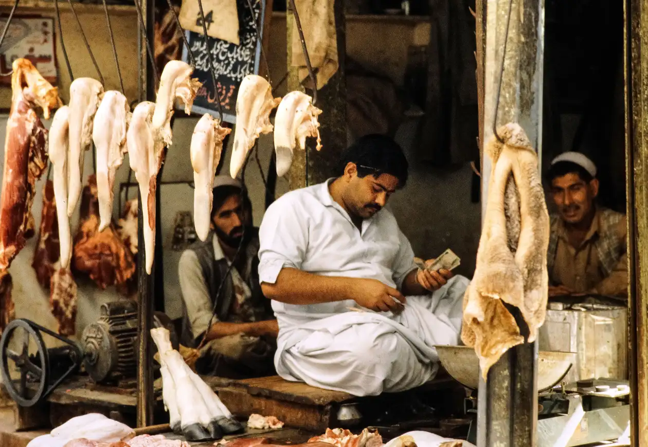 Traditional butcher shop scene in Pakistan with meat hanging on display